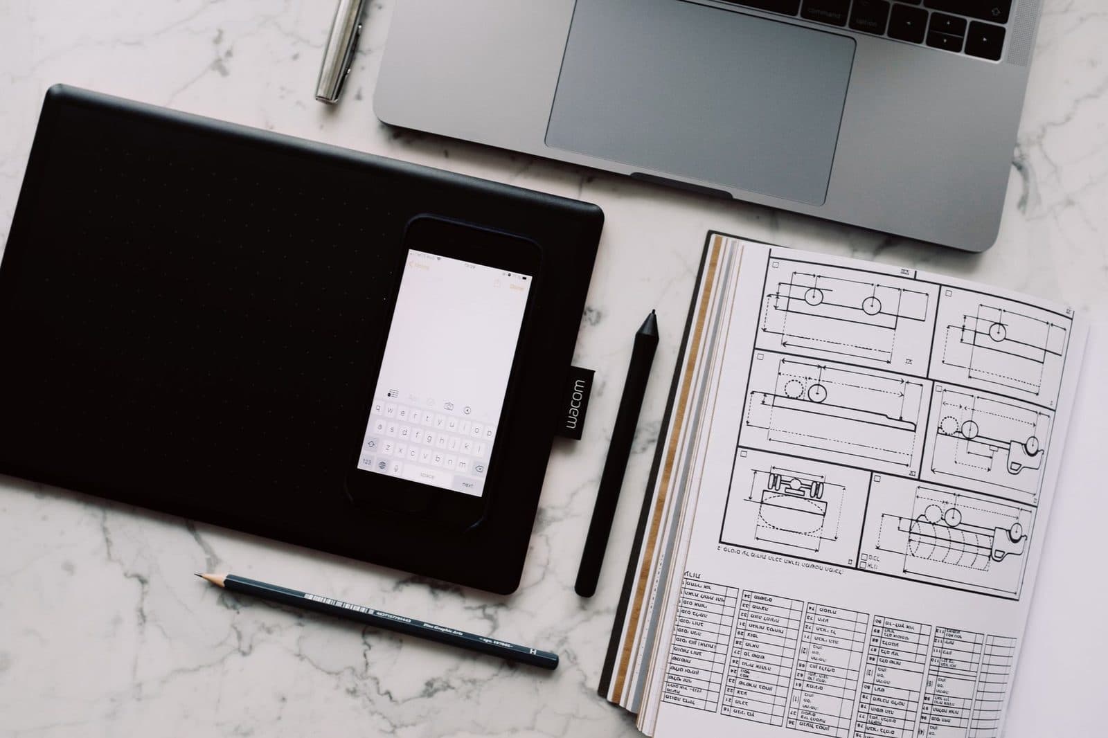 Graphic designer sketching layout ideas at a studio desk