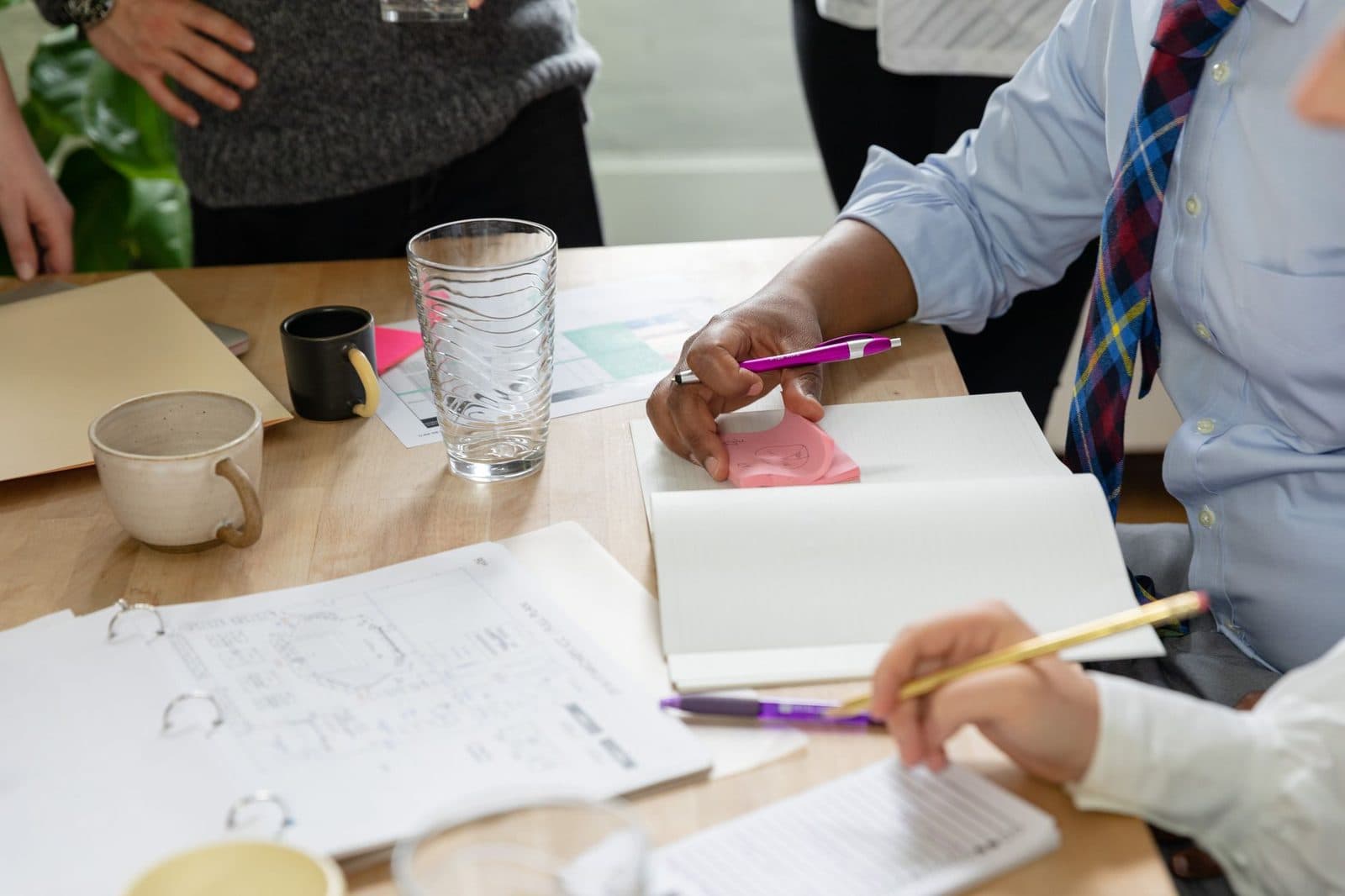 A studio team reviewing sketches, wireframes and notes around a desk